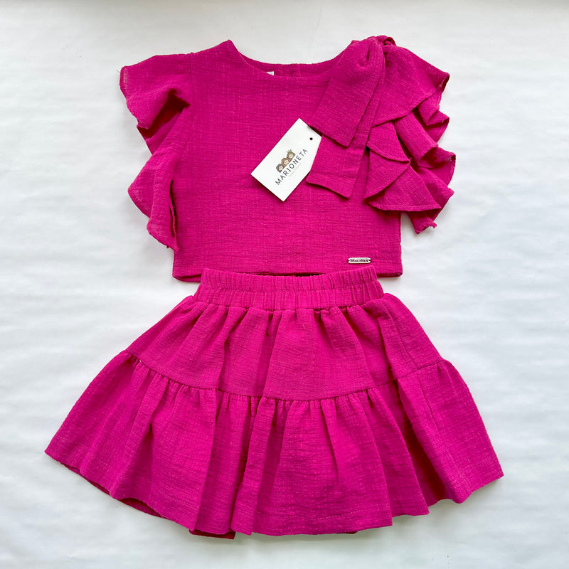 Conjunto dos piezas blusa y falda color rosa fiusha con adorno de lazo al hombro para niña |