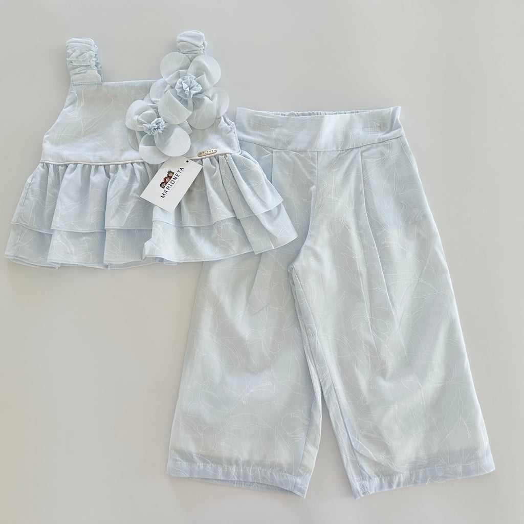 Conjunto dos piezas blusa con adorno de flores y pantlon azul para niña.