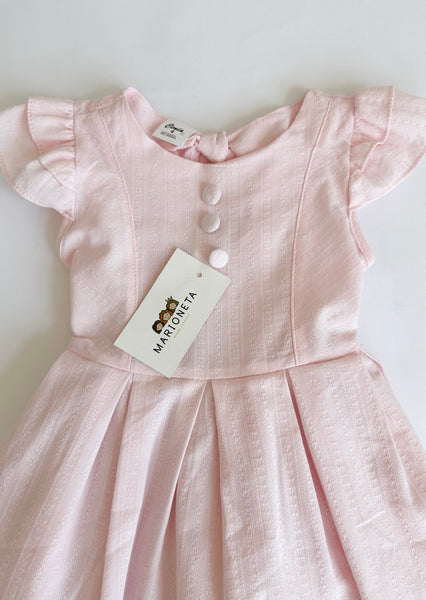 Vestido con detalle de botones y olanes color rosita para niña.