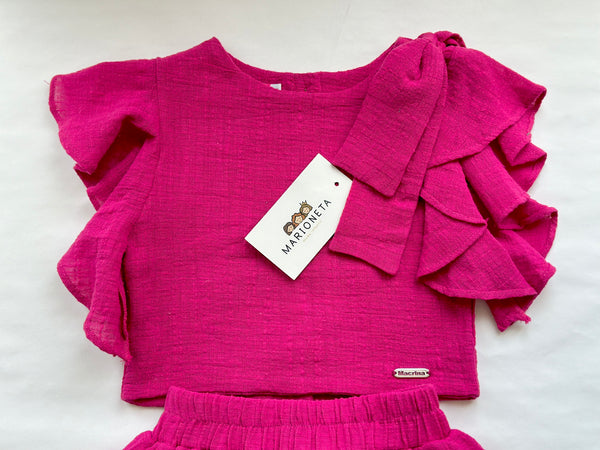 Conjunto dos piezas blusa y falda color rosa fiusha con adorno de lazo al hombro para niña |