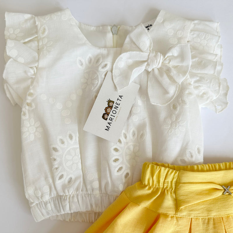 Conjunto dos piezas blusa blanca con detalle de moño y falda con olan color amarillo para niña.