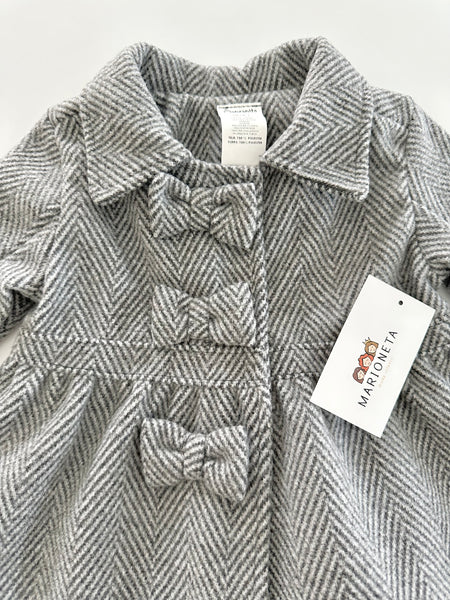 Abrigo color gris con adorno de lazos al frente para niña .|