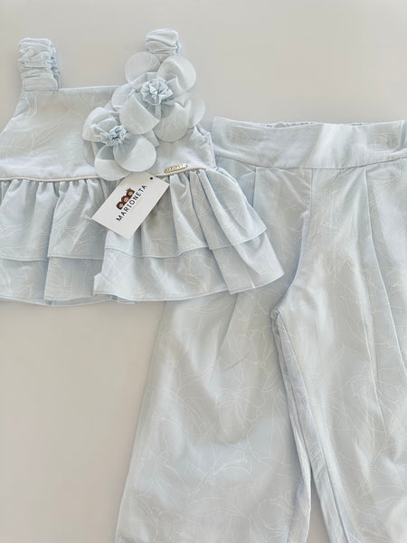 Conjunto dos piezas blusa con adorno de flores y pantlon azul para niña.
