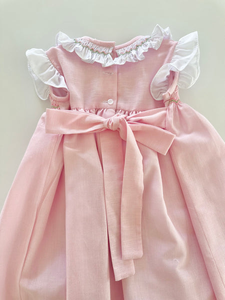 Vestido bordado hecho a mano color rosita con adorno en el cuello en blanco para niña .