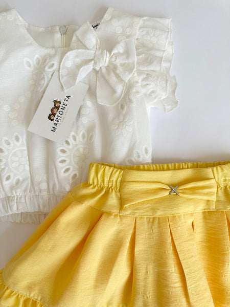 Conjunto dos piezas blusa blanca con detalle de moño y falda con olan color amarillo para niña.