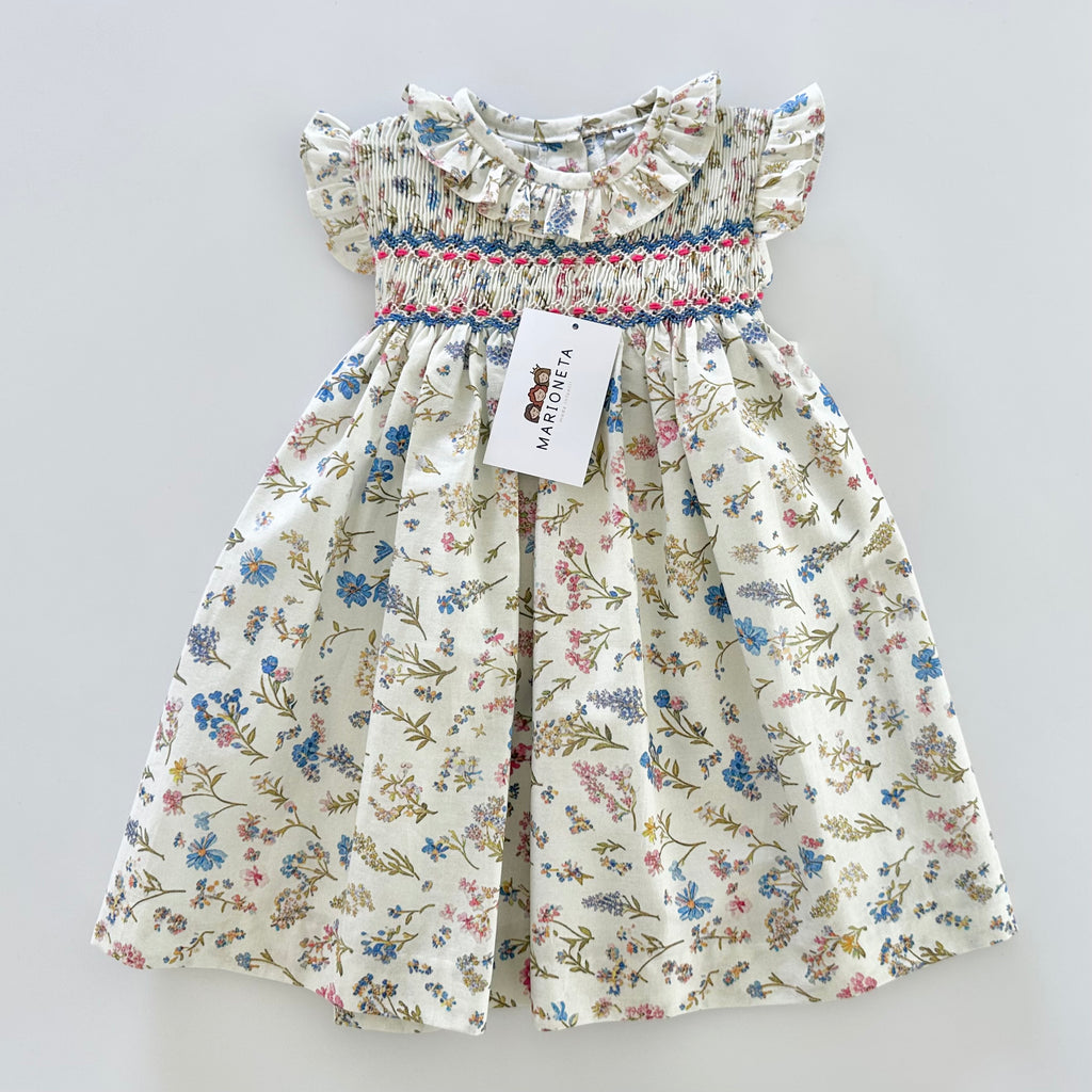 Vestido bordado hecho a mano color beige con estampado de flores azules para niña.