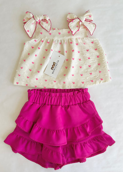 Conjunto dos piezas blusa ivory con estampado de corazones y lazos al frente y falda short fiucha para niña .