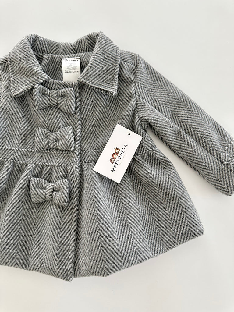 Abrigo color gris con adorno de lazos al frente para niña .|
