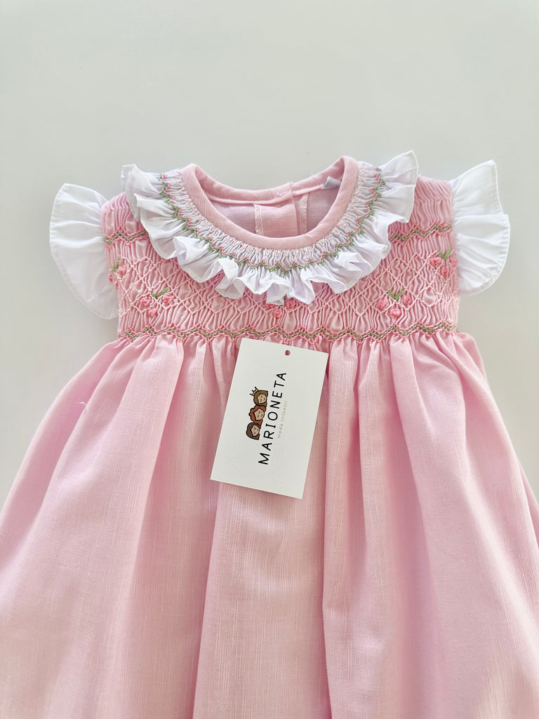 Vestido bordado hecho a mano color rosita con adorno en el cuello en blanco para niña .