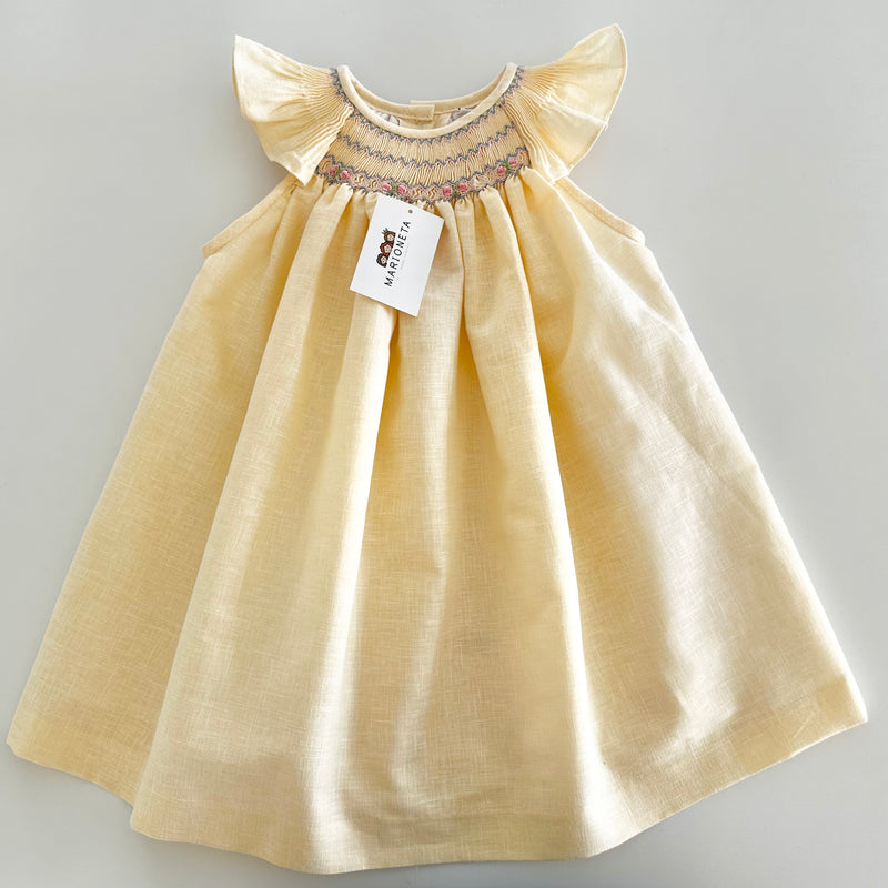 Vestido bordado hecho a mano Jesucito color amarillo bajito con bordado azul y rosa para niña.