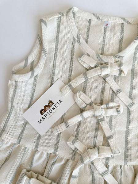 Conjunto dos piezas blusa con detalle de moños al frente y short beige con rayas verdes para niña.