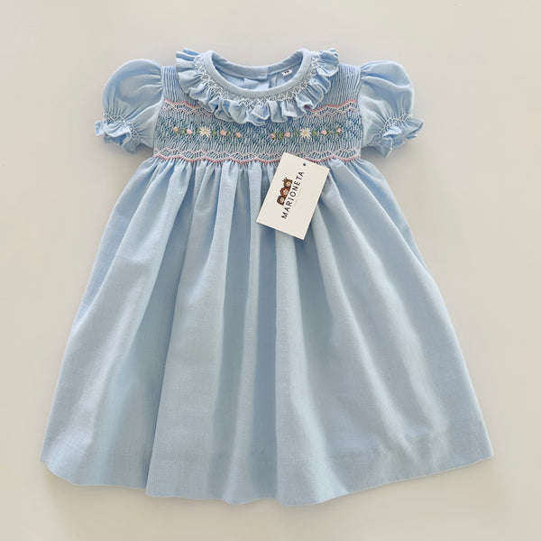 Vestido bordado hecho a mano color azul con adorno en el cuello y bordado con rosita |
