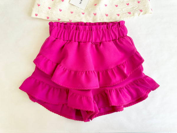 Conjunto dos piezas blusa ivory con estampado de corazones y lazos al frente y falda short fiucha para niña .