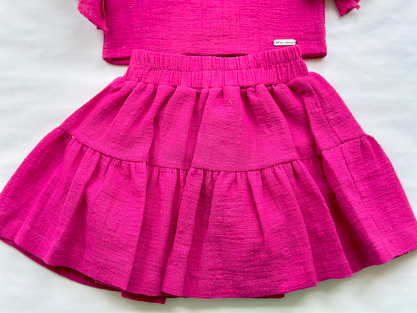 Conjunto dos piezas blusa y falda color rosa fiusha con adorno de lazo al hombro para niña |