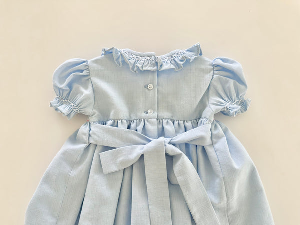 Vestido bordado hecho a mano color azul con adorno en el cuello y bordado con rosita |