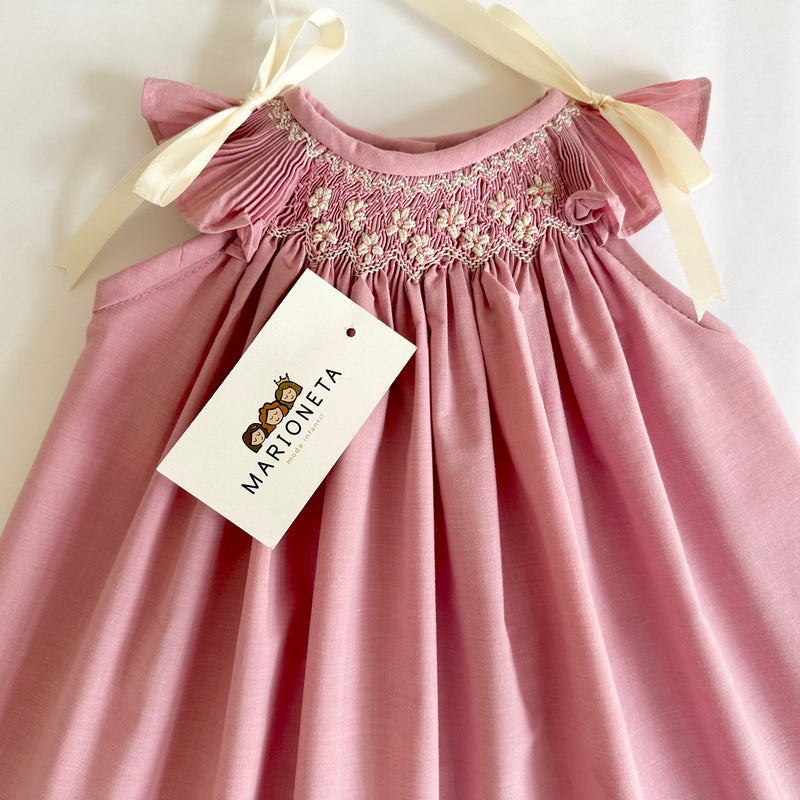 Vestido jesucito bordado hecho a mano color rosa con lazos y bordado en beige para niña.