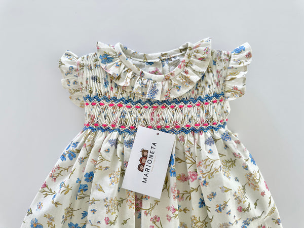 Vestido bordado hecho a mano color beige con estampado de flores azules para niña.