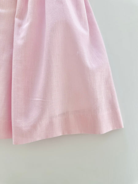 Vestido bordado hecho a mano color rosita con adorno en el cuello en blanco para niña .