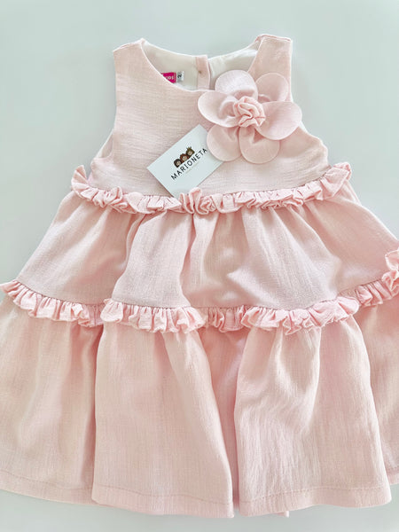 Vestido de olanes color rosita con adorno de flor en el frente para niña |