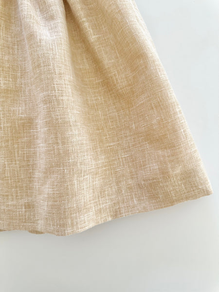 Vestido bordado hecho a mano color beige con adorno en el cuello blanco para niña.