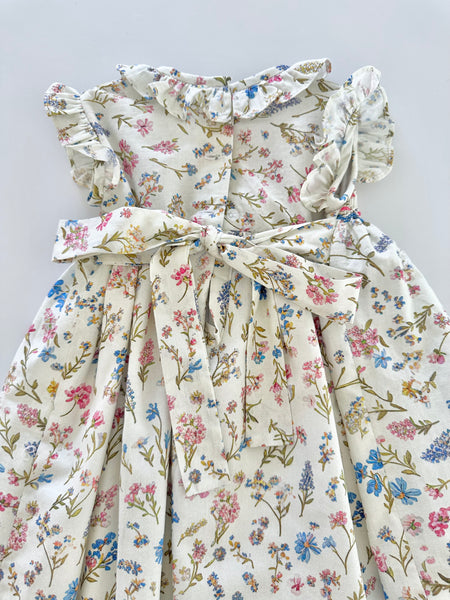 Vestido bordado hecho a mano color beige con estampado de flores azules para niña.
