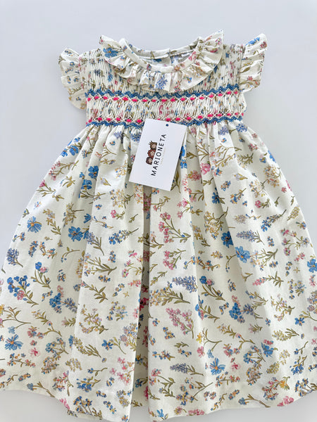 Vestido bordado hecho a mano color beige con estampado de flores azules para niña.