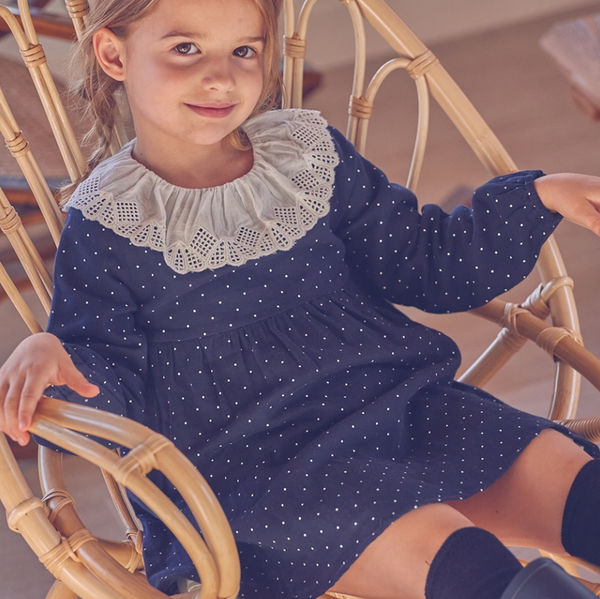 Vestido de niña azul marino con topos blancos y cuello Volante color crudo para niña. Dadati lo