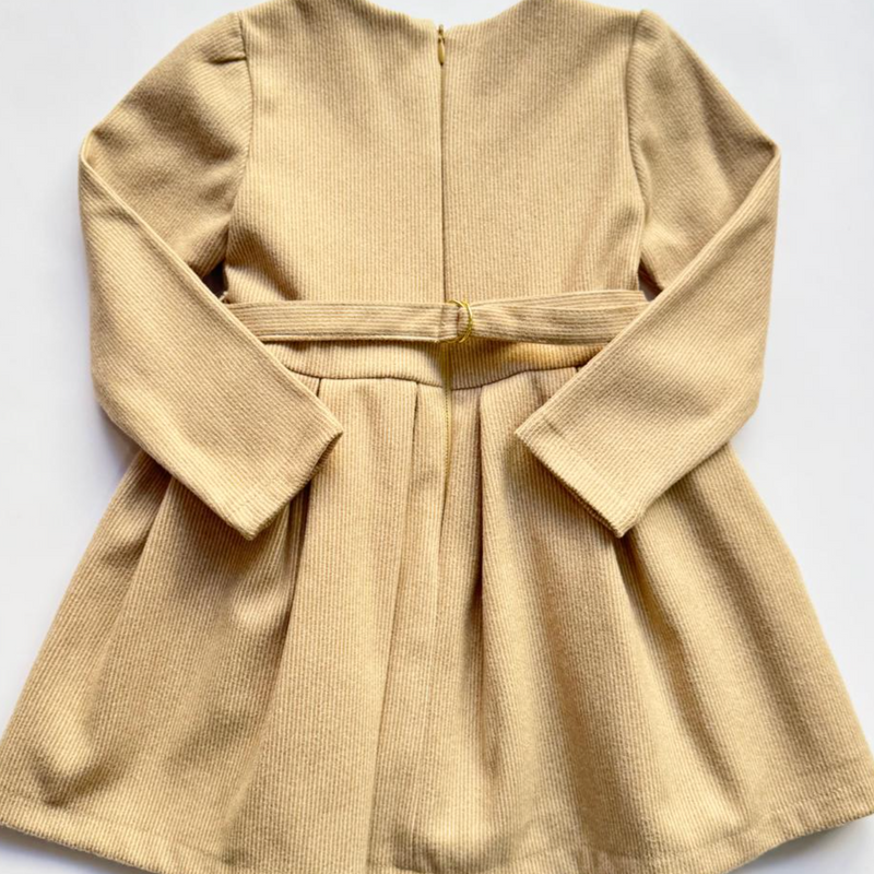 Vestido manga larga con moño al frente color beige para niña .
