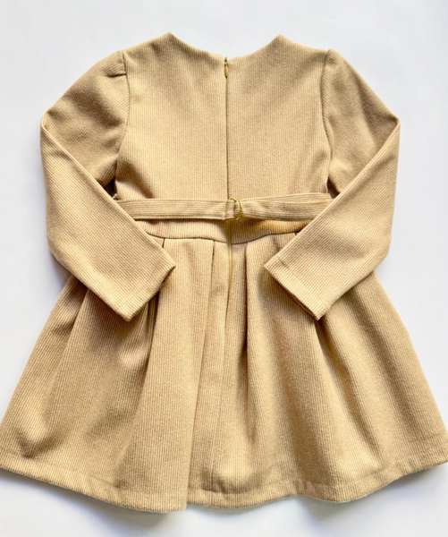 Vestido manga larga con moño al frente color beige para niña .