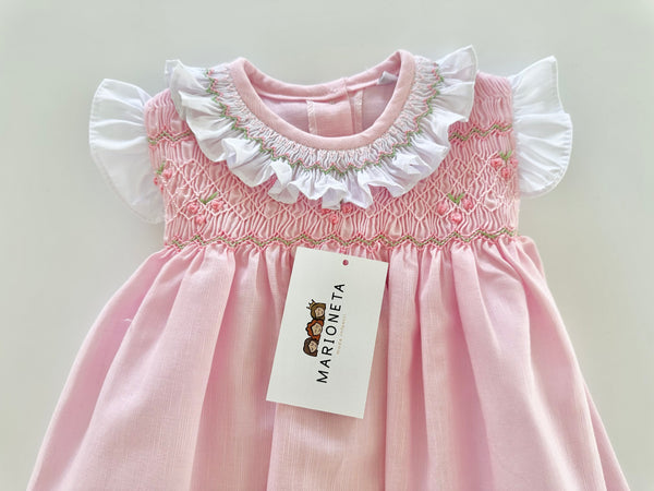 Vestido bordado hecho a mano color rosita con adorno en el cuello en blanco para niña .
