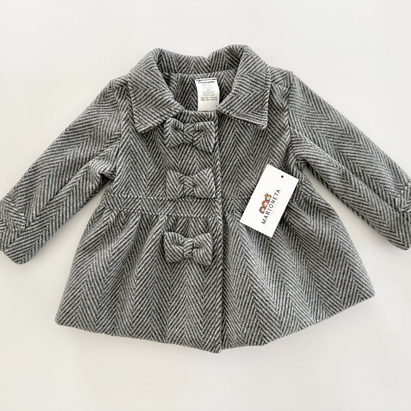 Abrigo color gris con adorno de lazos al frente para niña .|