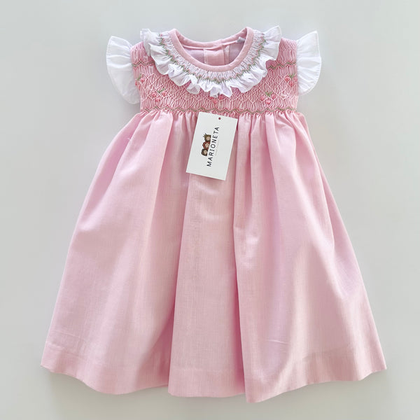 Vestido bordado hecho a mano color rosita con adorno en el cuello en blanco para niña .