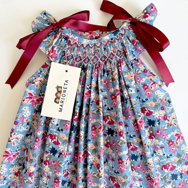 Vestido bordado hecho a mano azul con flores y lazos tintos en los hombros para niña | CARPI