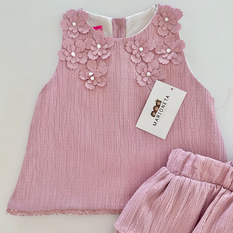 Conjunto dos piezas blusa con detalle de flores al frente y falda de olanes color rosa para niña.|
