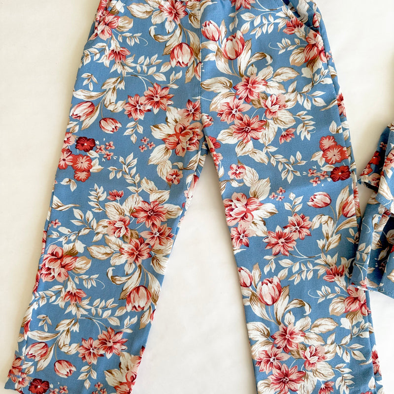 Conjunto dos piezas blusa azul estampada con olanes y lazo al frente y pantalon para niña.