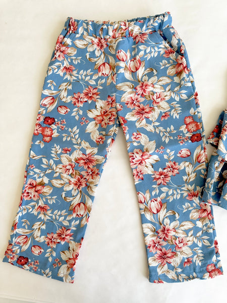 Conjunto dos piezas blusa azul estampada con olanes y lazo al frente y pantalon para niña.