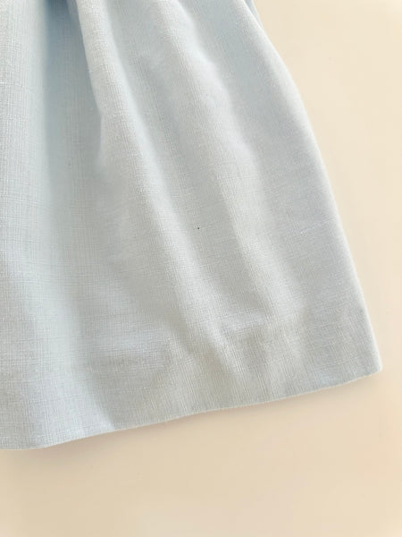 Vestido bordado hecho a mano color azul con adorno en el cuello y bordado con rosita |