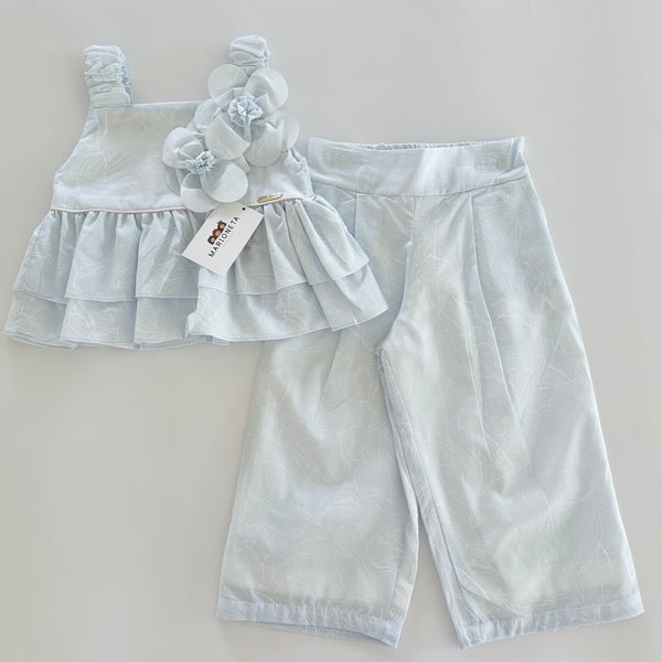 Conjunto dos piezas blusa con adorno de flores y pantlon azul para niña.