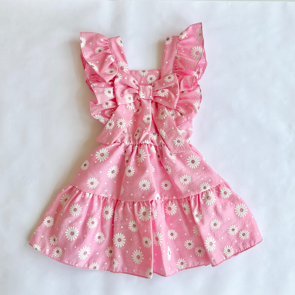 Vestido rosa con estampado de margaritas blancas con adorno de olanes y lazo atras para niña | mexicana