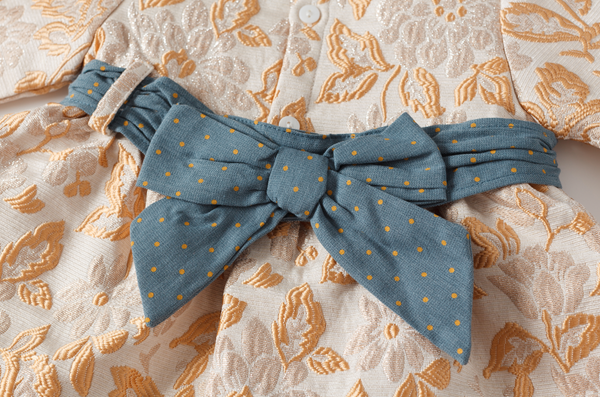 Vestido beige y dorado con olan y moño azul para bebe niña | Newness